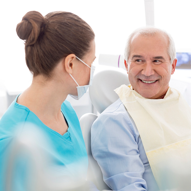 Elderly Man Talking with Dentist