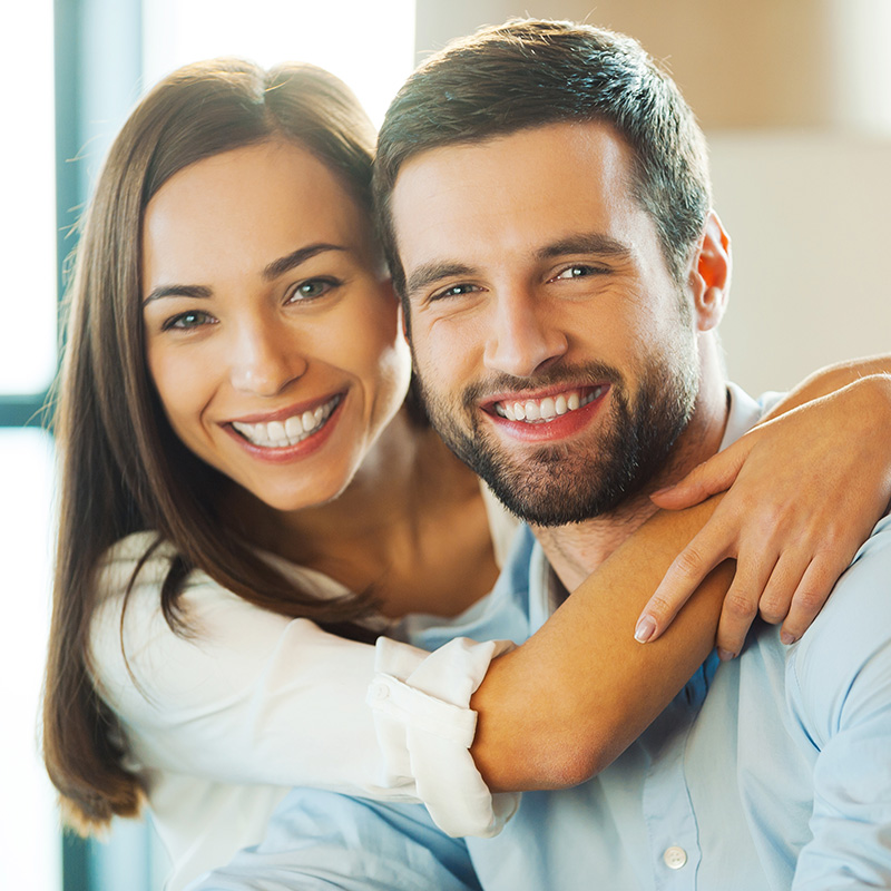 Couple Smiling and Holding onto Each other On Couch