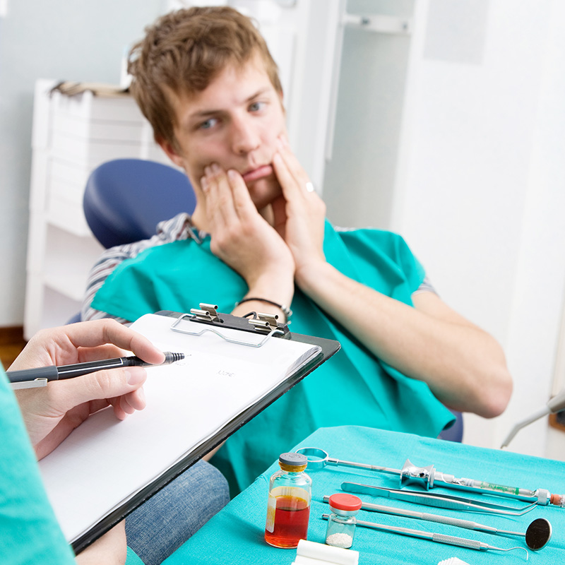 Man in Dentist Chair with Pain in Gums